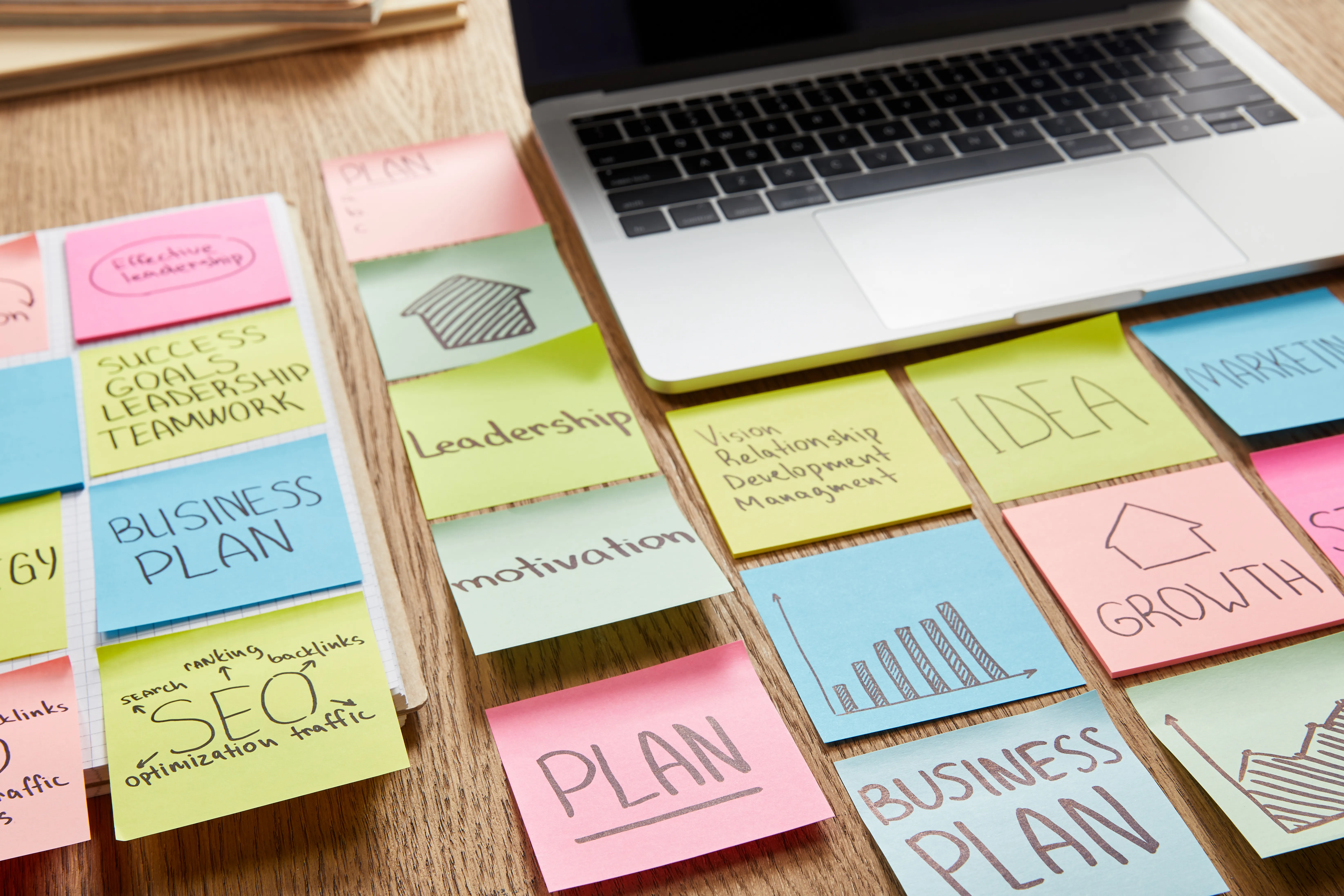Ordinateur entouré de post-it sur l'optimisation d'un projet
