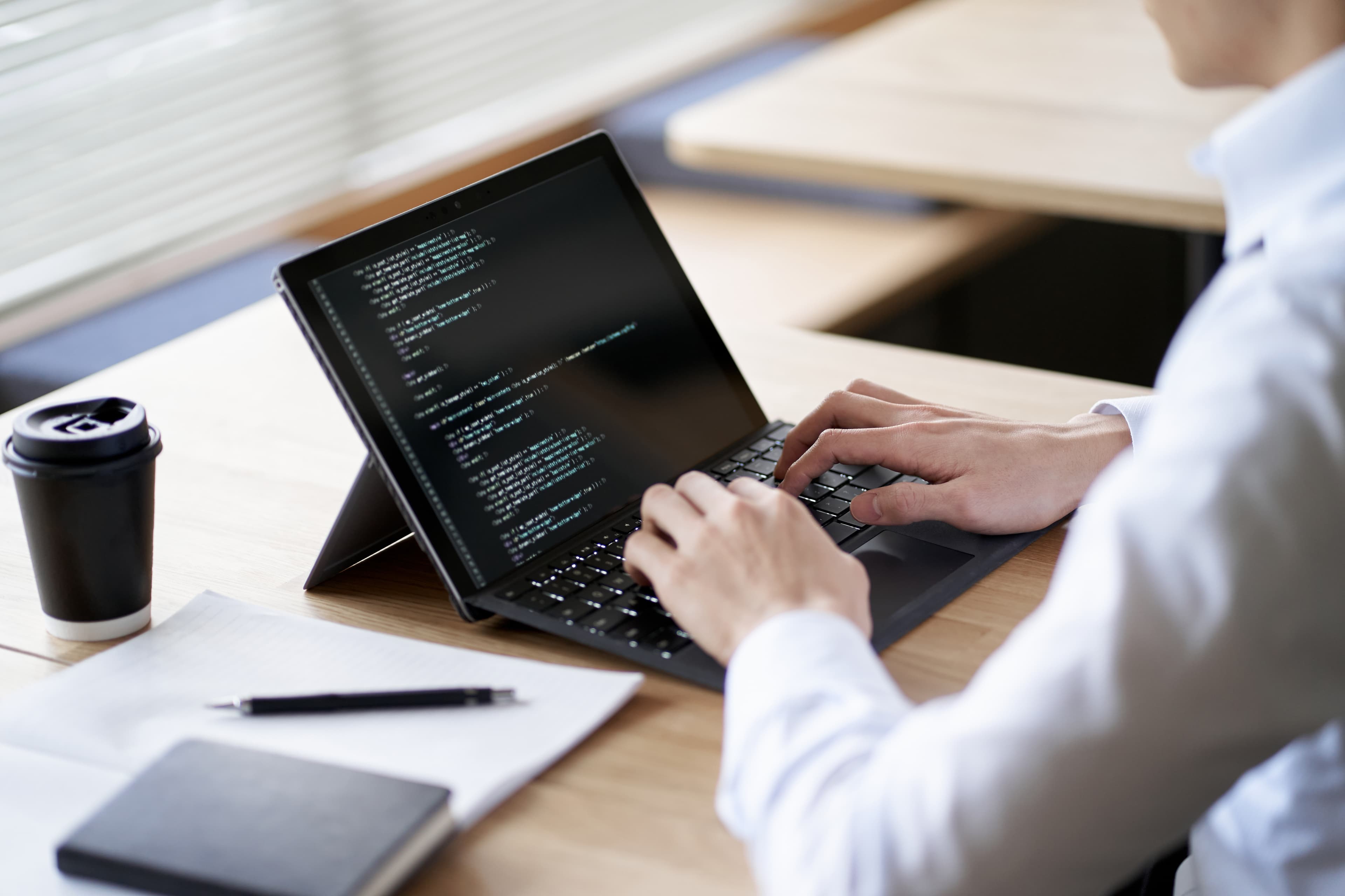 Développeur qui rédige du code sur une tablette